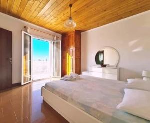 a bedroom with a large bed with a large window at Irini Studios in Alykes