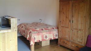 a bedroom with a bed and a wooden cabinet at Südblick in Röttenbach