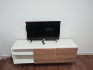 a flat screen tv on top of a white desk at kit Catavento in Brasilia