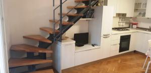 una escalera de caracol en una cocina con TV en Casa Allegra en Nápoles