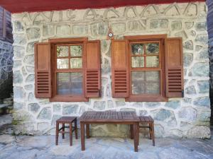 a stone house with a wooden table and two windows at Mencuna Konaklari in Arhavi