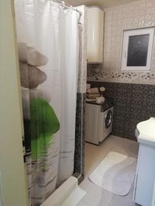 a bathroom with a shower with a white shower curtain at Fenix Zlatar in Nova Varoš