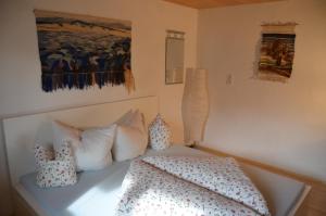 Un dormitorio con una cama con almohadas y una pintura en Ferienwohnung Serlesblick, en Mieders