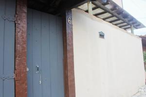 a garage with a blue door and a brick building at Central Flat 2 quartos - Centro de Búzios in Búzios