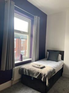 a bed in a room with a window and a bedvisor at Alexandra House in Goole