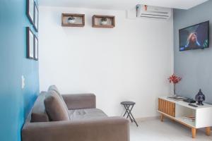 uma sala de estar com um sofá e uma televisão em Studio Centro de Búzios em Búzios