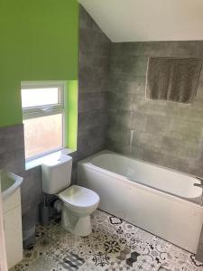 a bathroom with a toilet and a tub and a sink at Alexandra House in Goole