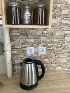 a tea kettle sitting on a counter in front of a stone wall at Find for the traveler in Tallinn