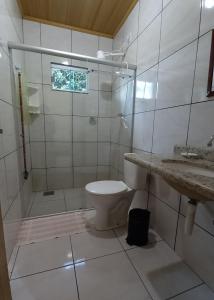 uma casa de banho com um WC, um chuveiro e um lavatório. em POUSADA CANTO DOS PÁSSAROS em Alto Paraíso de Goiás