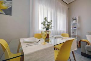 een eetkamer met een tafel en gele stoelen bij 13 Avenida Andalucía in Ronda