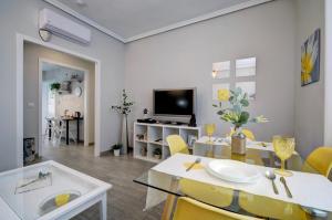 sala de estar con mesa y sillas amarillas en 13 Avenida Andalucía, en Ronda
