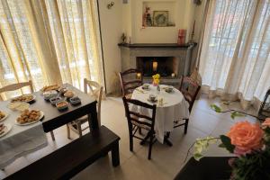 uma sala de jantar com uma mesa e uma lareira em Dianthos Guesthouse em Kiriákion