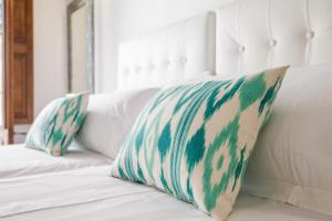 a green and white pillow on a white couch at Can Boss - Turismo de Interior in Palma de Mallorca