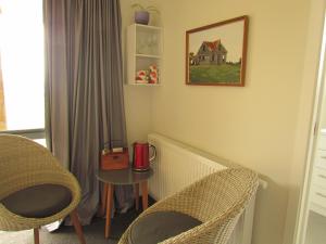 a room with chairs and a table and a picture on the wall at The Bunkhouse in Waiau