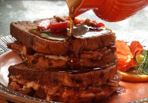 a stack of bread with sauce being poured on top at Ray's Bucktown Bed and Breakfast in Chicago