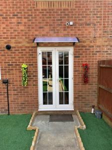 a front door of a brick building with flowers on it at Modern 5 Bedroom House in Willesborough
