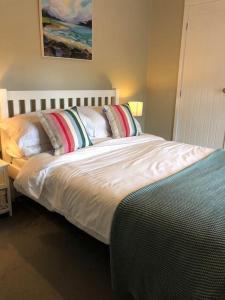 una camera da letto con un letto con lenzuola e cuscini bianchi di New Station Cottage, country views, great location a Sledmere