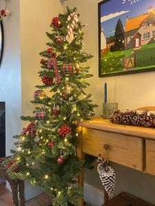 a christmas tree with ornaments on it in a room at New Station Cottage, country views, great location in Sledmere