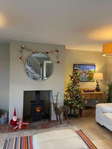 een woonkamer met een kerstboom en een spiegel bij New Station Cottage, country views, great location in Sledmere