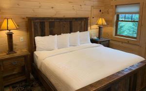 a bedroom with a large bed with two lamps on tables at Briarwood Cabin by Amish Country Lodging in Berlin