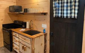 a kitchen with a sink and a stove and a door at Briarwood Cabin by Amish Country Lodging in Berlin
