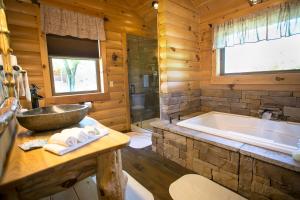 a bathroom with a large tub and a sink at Dogwood Cabin by Amish Country Lodging in Berlin