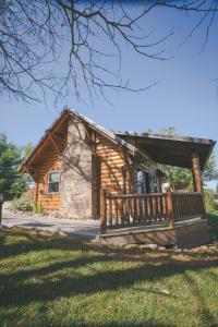 a log cabin with a bench in front of it at Dogwood Cabin by Amish Country Lodging in Berlin