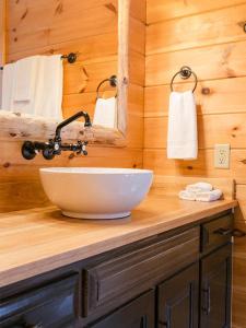 a bathroom with a bowl sink and a mirror at Farmhouse Suites by Amish Country Lodging in Millersburg