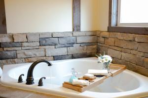 a bathroom with a bath tub with a sink at Country Bliss Cottage by Amish Country Lodging in Berlin
