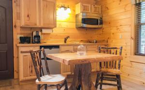 a kitchen with a table and chairs in a cabin at Lofty Willows Treehouse by Amish Country Lodging in Millersburg