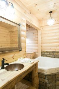 y baño con lavabo y bañera. en Hummingbird Haven Cabin by Amish Country Lodging, en Berlin