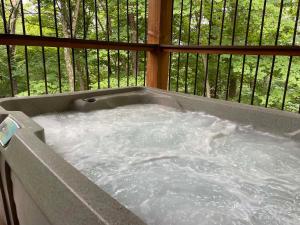 a jacuzzi tub with water in a balcony at Treehouse #0 by Amish Country Lodging in Millersburg