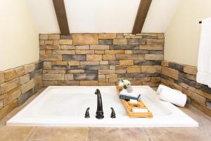 a bathtub in a room with a brick wall at Village Dreams Cottage by Amish Country Lodging in Berlin