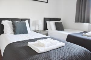 a hotel room with two beds with towels on the bed at Stafford House in Norwich