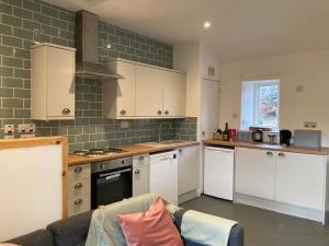 una cucina con armadi bianchi e un divano di Charleton Farm Cottages a Montrose