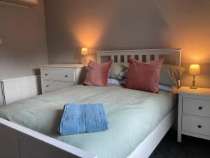 una camera da letto con un letto bianco con due comodini di Charleton Farm Cottages a Montrose