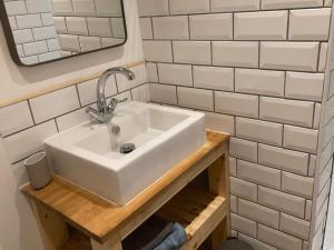 bagno con lavandino e pareti bianche piastrellate di Charleton Farm Cottages a Montrose Altre 3 foto