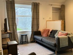 un soggiorno con un divano e una finestra di Charleton Farm Cottages a Montrose