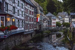 a bridge over a river in a town with buildings at Sommerhaus am Nationalpark Eifel mit Sauna in Monschau