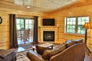 ein Wohnzimmer mit einem Sofa und einem Kamin in der Unterkunft Waterview Lodge by Amish Country Lodging in Millersburg