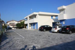 un estacionamiento con autos estacionados frente a un edificio en RESIDENCE BLUMAR 2, en Lido di Jesolo