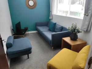 a living room with a blue couch and chairs at The Old Post Box in Leeds