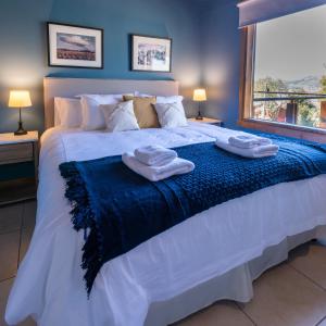 ein Schlafzimmer mit einem großen weißen Bett mit Handtüchern darauf in der Unterkunft Oliver Mountain Home Blue in San Martín de los Andes