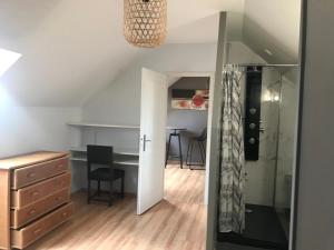a room with a desk and a closet with a mirror at Chez Chris in Oloron-Sainte-Marie