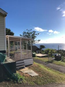 a porch on a house with a view of the ocean at PANORAMA Ocean View Cottage in Motobu