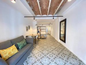 - un salon avec un canapé et une table dans l'établissement Liceu Apartments by gaiarooms, à Barcelone
