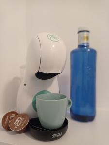a coffee maker and a cup next to a blue bottle at Martínez Rooms Pilgrims in Caldas de Reis