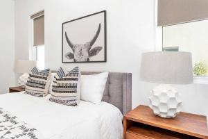1 dormitorio con 1 cama con 2 mesas y una foto de un ciervo en Villa 19 - LUXURY GOLF VILLA, BEST VIEW, YEAR ROUND HEATED POOL & HOT TUB! en St. George