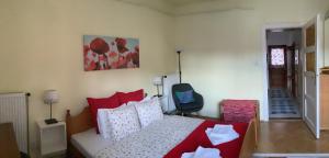 a bedroom with a bed with red and white pillows at Poppy Flower Apartment in Budapest