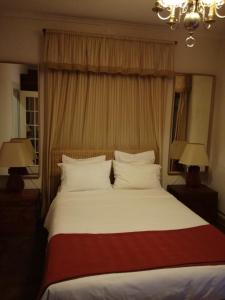 a bedroom with a large white bed with two lamps at Estrela Park in Lisbon